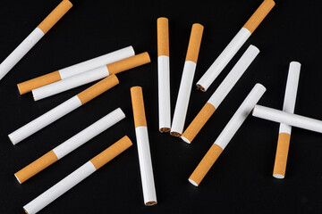 Group of cigarettes lying isolated on black background