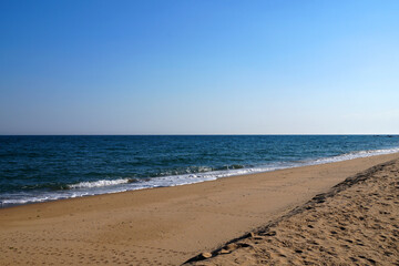 Fototapeta na wymiar empty sandy beach, sea horizon and clear sky