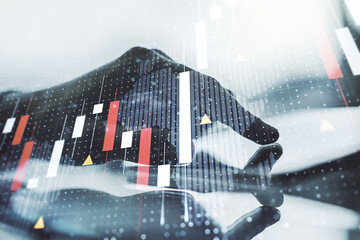 Abstract creative financial graph with world map and finger clicks on a digital tablet on...