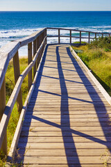 Beach with wooden path to sea water.