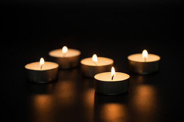 Fototapeta na wymiar candles burning at night.Many candle flames glowing on dark background