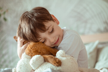 Little kid boy holding and hugging red cat somli breed kitten. People children kids with pets concept.