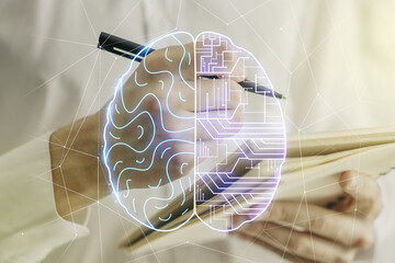 Creative artificial Intelligence concept with human brain hologram and man hand writing in notebook...