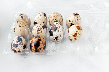 soft focus of uncooked quail eggs in tray on white background with copy space