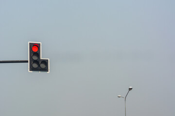 Red traffic lights on road with sky background.