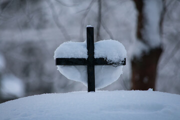 Heart-shaped Snow on a Cross. A lot of snow covered everything on the  ground like the cemetery's...