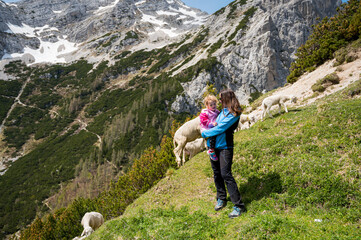 Naklejka na ściany i meble Mother and daughter posing in the mountains enjoying fresh air.