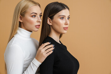 Beautiful young two women posing and looking aside