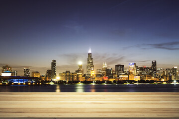 Blank wooden tabletop with beautiful Chicago skyline at night on background, mockup