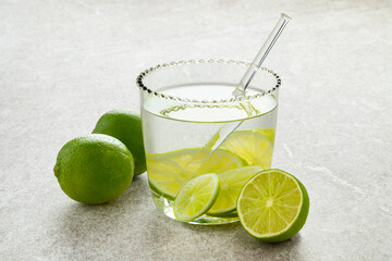  Fresh green limes and glass of water with lime slices