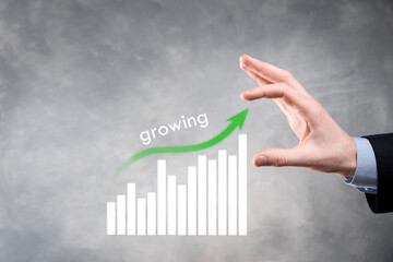 Business man holding holographic graphs and stock market statistics gain profits. Concept of growth...