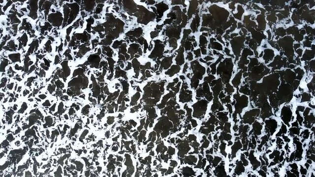 Aerial top down view of waves at Ladghar beach Dapoli, located 200 kms from Pune on the West Coast of Maharashtra India.