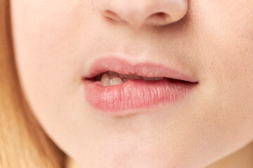 Close-up photo of a woman biting her lips against