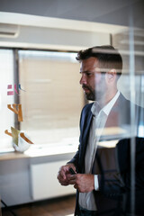Fototapeta premium Businessman in conference room. Young businessman in suit making a business plan.