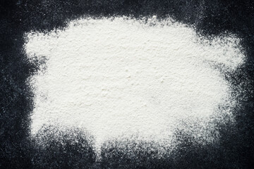 Baking background. Sprinkled flour on black background, top view with copy space.