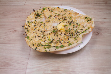 indian special flat bread also known as butter tandoori roti or naan, served in a white ceramic quarter plate
