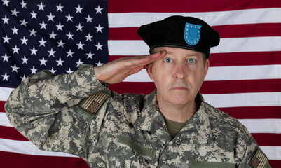 Man saluting while wearing military outer shirt and beret with US flag in background