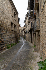narrow cobblestone street with massive brown stone houses