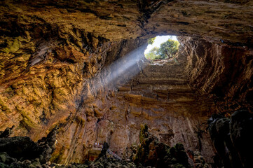 La Grave abyss of Grotte di Castellana with ray of sunlight in Puglia