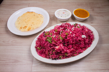 Beet risotto prepared with beet puree, roasted beet slices and parsley on top, photographed with...