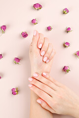 Female beautiful hands on a background of rosebuds 