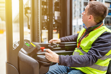 Storehouse employee in uniform working on reachtruck in modern automatic warehouse. Warehousing, machinery concept. Logistics in stock.