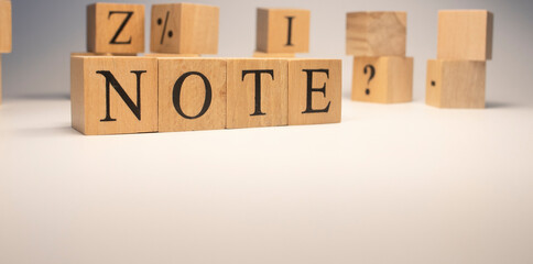 The word note is from wooden cubes. Background from wooden letters.