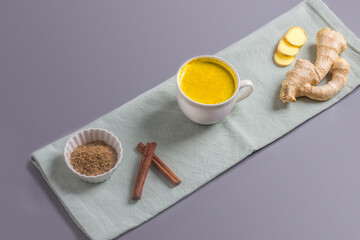 Moon milk for better sleep. Turmeric Golden Milk with Cinnamon. Ayurvedic drink. Popular drink. Golden latte on a light background. Indian drink turmeric golden milk in a cup