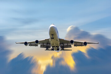 front image commercial passenger aircraft or cargo transportation airplane fly to sky with sunshine and cloudy (background effect motion blur)