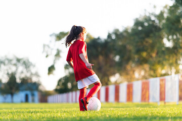 Little girl kicks soccer ball