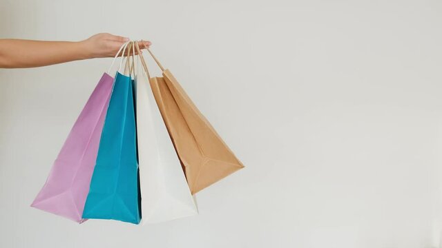 Woman's hand holding a fashionable shopping bag and a beauty