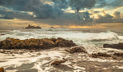 Beautiful seascape, ocean views, rocky coast, sunlight on the horizon. Composition of nature. Sunset scenery background. Cloudy sky. Water Reflection. California Seashore.