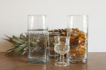 Pineapple behind the glass of water. Reflection of pineapple in a glass of water. Abstract food background.
