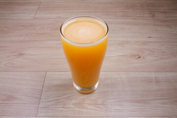 citrus juice in glass decanter with orange on wooden background. Horizontal orientation. Copy space.