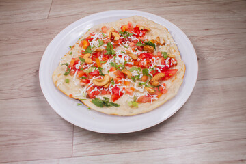Uthappam or Uttapam is a type of dosa from southern India that is thicker, with tomato, onion, chilli packets,cashew nut and cheese