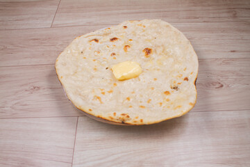 indian special flat bread also known as butter tandoori roti or naan, served in a white ceramic quarter plate