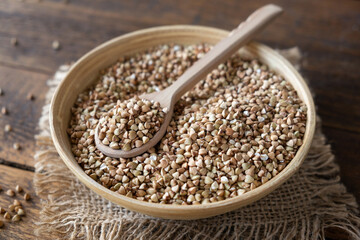 Green buckwheat in a bowl on wooden table. Healthy vegan food