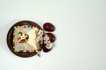Easter composition. Eggs, apricot flowers and Orthodox Easter cottage cheese dessert in the form of a pyramid on a white background. Happy Easter Holidays. Top view. Free space.