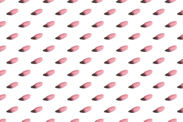 Pills on a white background. Pink pill pattern. Hard shadows
