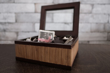 dear to heart memorabilia in an old wooden box, a stack of retro photos, vintage photographs of 50s, 60s, concept of family tree, genealogy, connection with ancestors