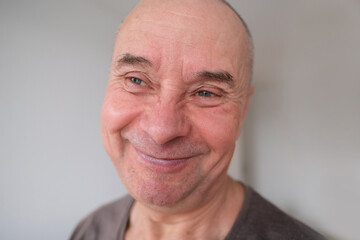 face of European old man close up, wrinkles on aging skin, smiling, good mood concept, cosmetology, age-related changes