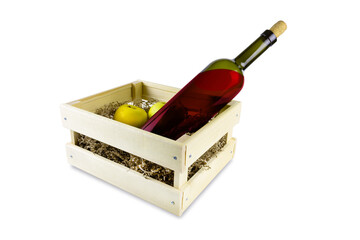 Bottle of red wine with cork and two yellow apples in wooden box with paper shavings, isolated on...