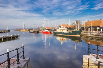 Fototapeta na wymiar Jetties and ships in the historic harbor of Hindeloopen, Netherlands