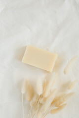 Natural unscented soap bar on white linen background