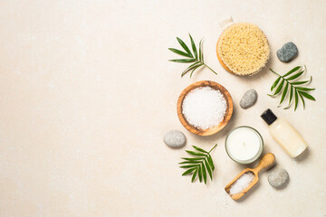 Spa background. Spa product composition with palm leaves, cosmetic and sea salt at stone table....