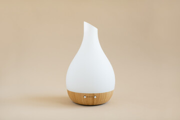 White and wood essential oil diffuser on tan background