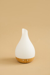 White and wood essential oil diffuser on tan background