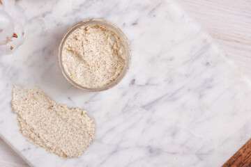 Natural body scrub on marble background. Cosmetic face cream container with care cruelty-free product. Flat lay, top view