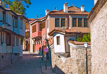 The charming narrow alley in upper old medieval city with traditional ottoman houses with hanging balconies. Plovdiv, Bulgaria