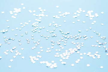 Silver shiny stars glitter or confetti on blue background